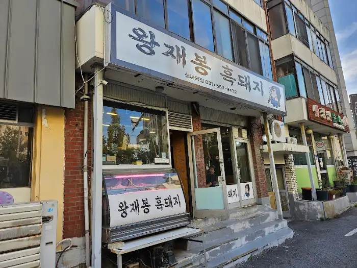왕재봉 흑돼지 건물 전면 모습, 간판과 진열장이 보인다