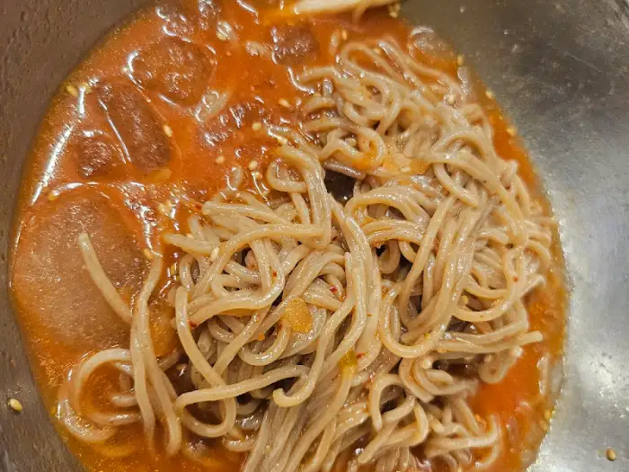 김치찌개 또는 냉면으로 추정되는 음식 클로즈업