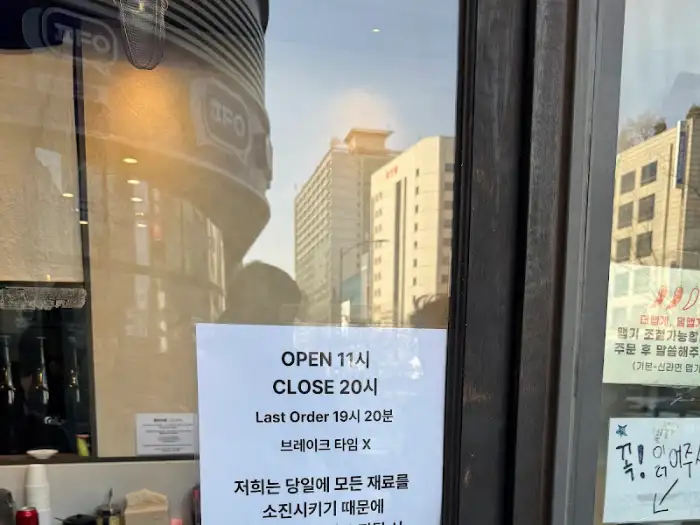 가게 외부 창문에 부착된 운영 시간 안내문