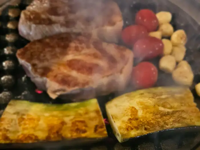 맛있게 구워지고 있는 목살과 곁들임 채소