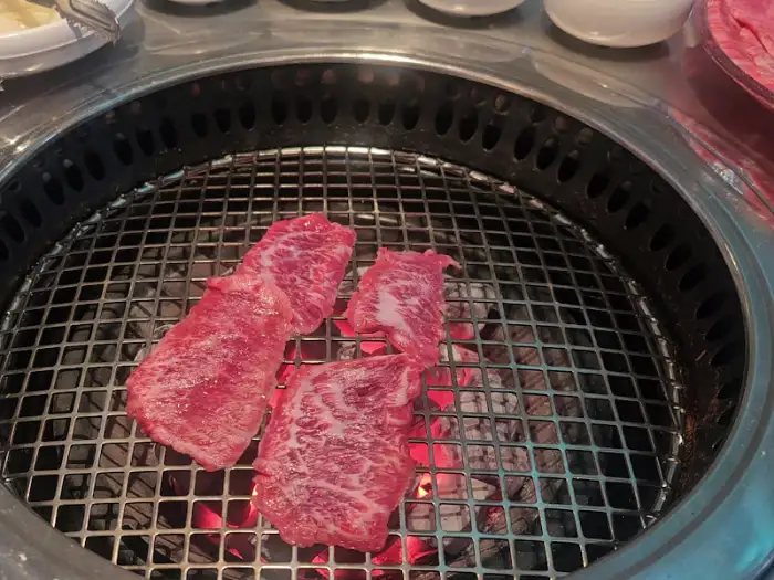 그릴 위에서 익고 있는 얇게 썬 고기