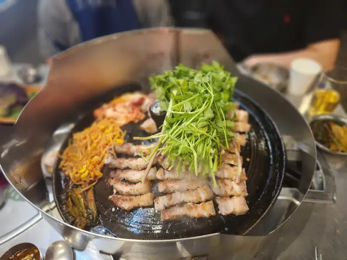 솥뚜껑 위 삼겹살과 미나리