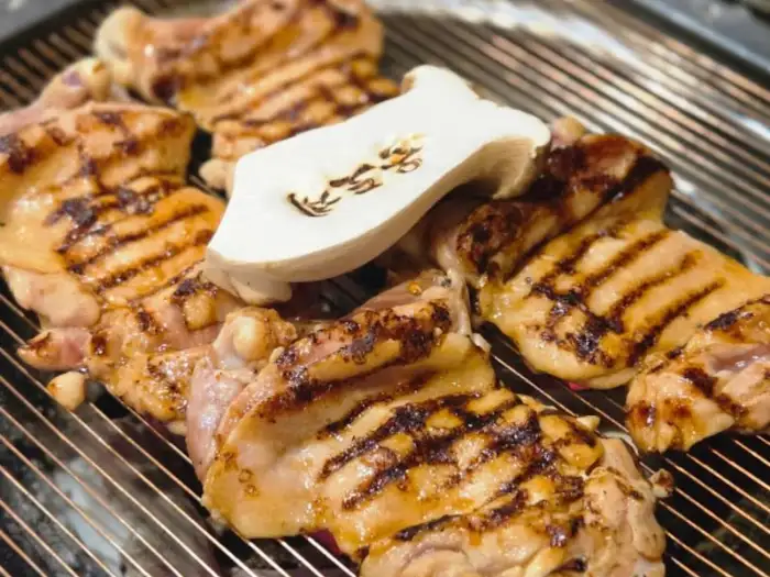 숯불 위에서 맛있게 구워지고 있는 고기와 버섯