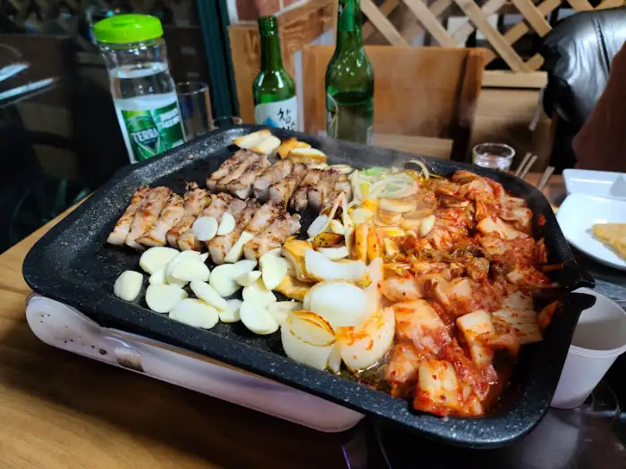 잘 익어가는 삼겹살과 마늘, 양파