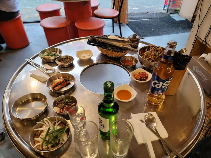테이블 위에 차려진 다양한 밑반찬과 술병