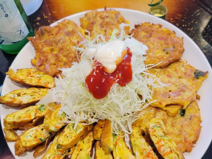테이블에 놓인 참치전과 계란말이, 그리고 술병