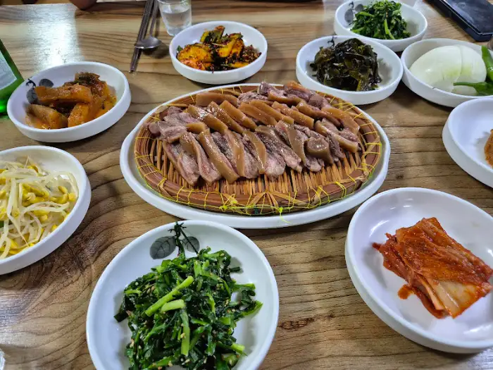 쟁반 위에 푸짐하게 담긴 슬라이스된 고기와 여러 반찬들.