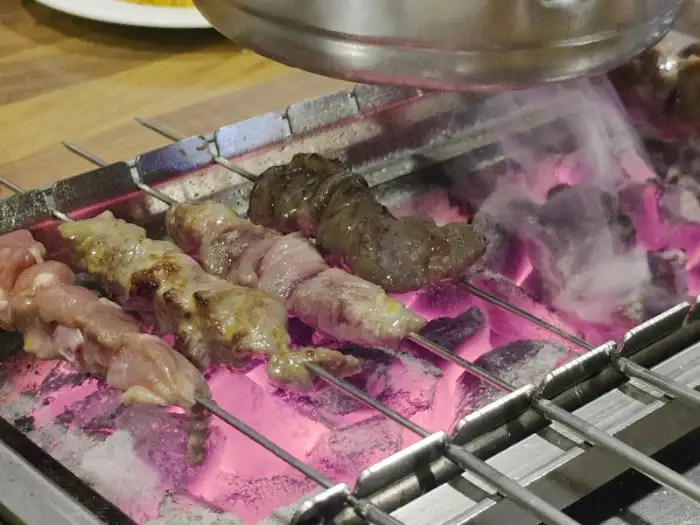 불판에 올려진 양꼬치 꼬치들의 모습