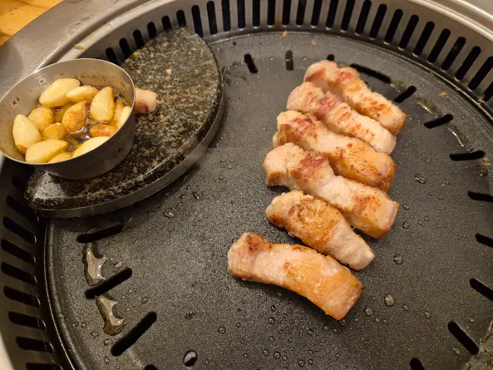 맛찬들왕소금구이 과천점 구워지는 삼겹살과 떡