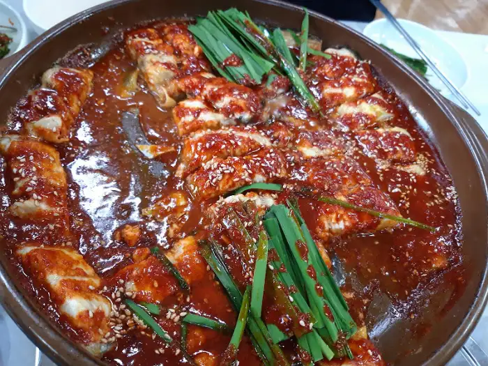 접시에 덜어낸 메기구이 조각과 부추