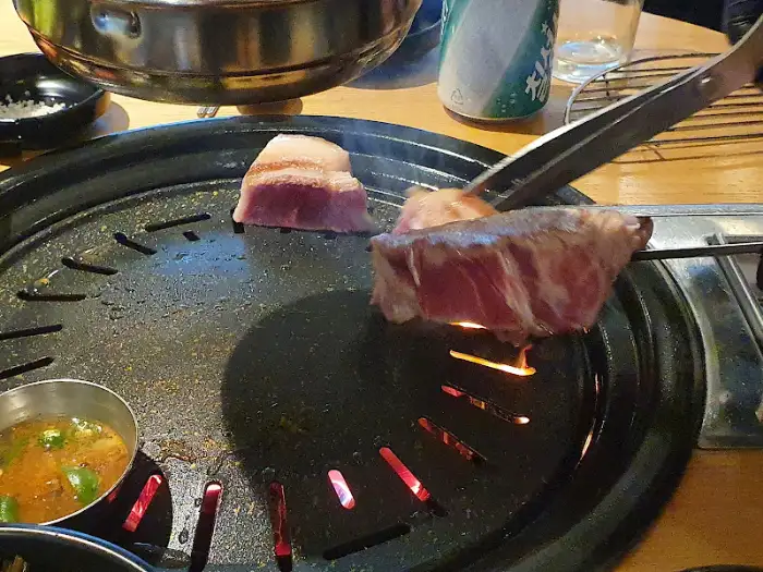 집게로 고기를 뒤집는 모습