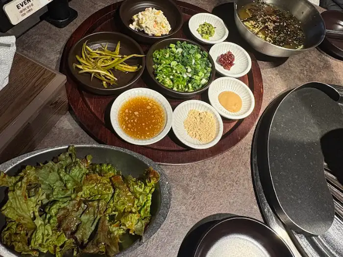 테이블 위에 차려진 다양한 곁들임 찬들과 막창, 그리고 묵사발