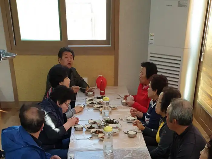 식당 내부 모습, 여러 테이블에 둘러앉아 식사 중인 사람들