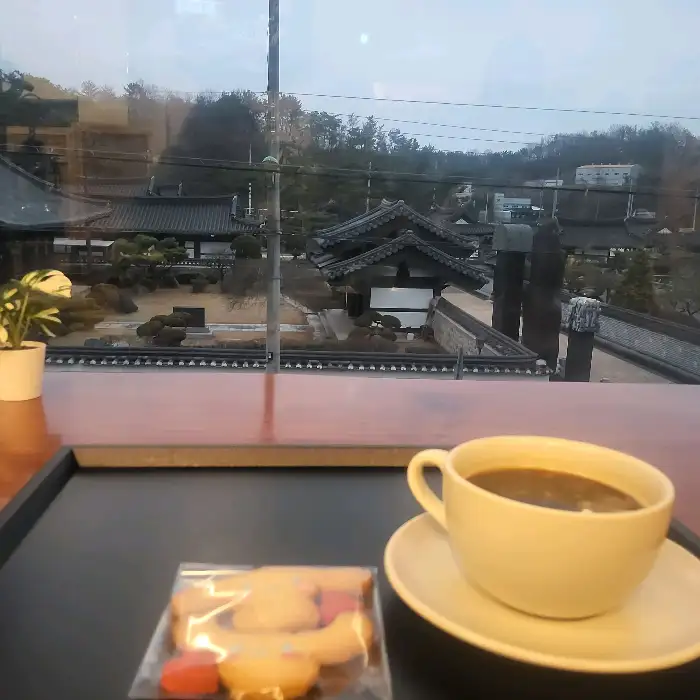 한옥 풍경을 배경으로 커피와 쿠키가 놓인 테이블