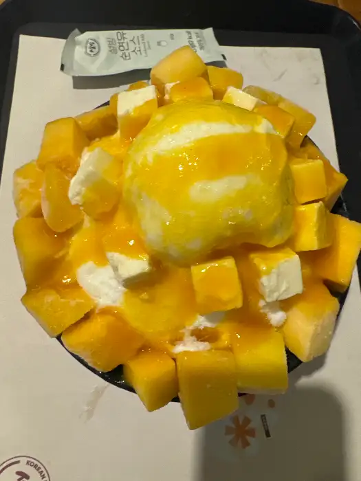 망고 조각과 아이스크림이 듬뿍 올라간 빙수