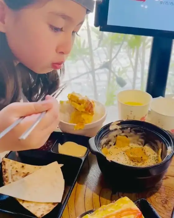 한 아이가 젓가락으로 음식을 집어먹고 있는 모습