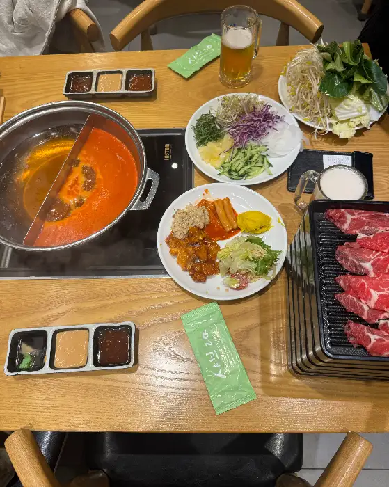 테이블에 차려진 샤브샤브 재료와 육수