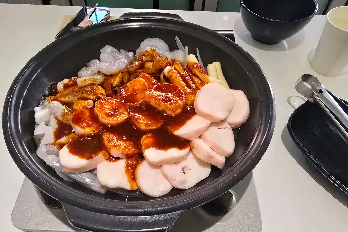낙곱새 메인 메뉴 사진. 푸짐한 낙지, 곱창, 새우와 떡, 당면 등이 양념에 버무려져 있다.