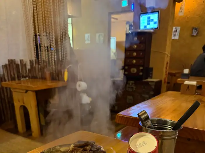 은은한 조명과 나무 테이블이 있는 매장 내부