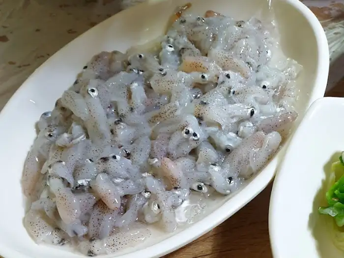 작고 신선한 오징어들이 접시에 담겨 있는 모습