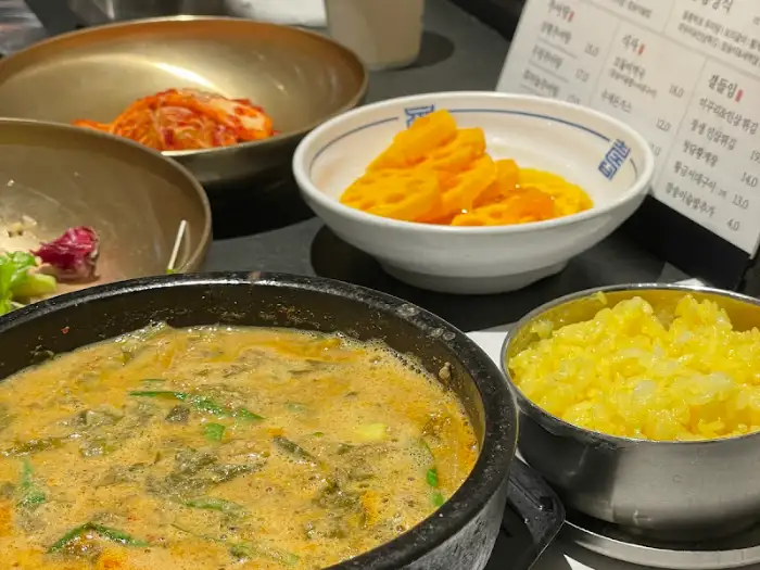 추어탕과 밥, 그리고 다양한 밑반찬이 차려진 모습