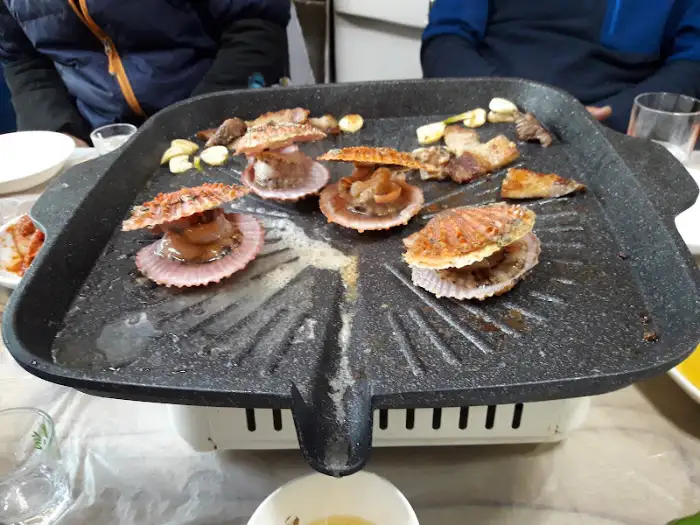 철판 위 가리비와 삼겹살 근접 촬영