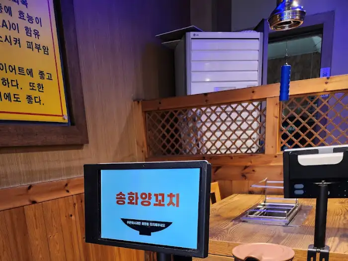 테이블에 놓인 태블릿 PC에 송화양꼬치 상호명이 표시되어 있습니다.