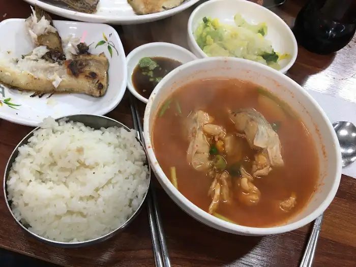 흰 쌀밥 위에 올려진 생선구이와 얼큰한 탕