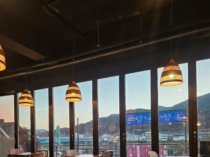 따뜻한 느낌의 조명과 통창 너머로 보이는 풍경