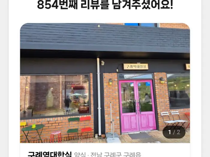 가게 입구 모습. 벽돌 건물에 화려한 핑크색 문이 있습니다.