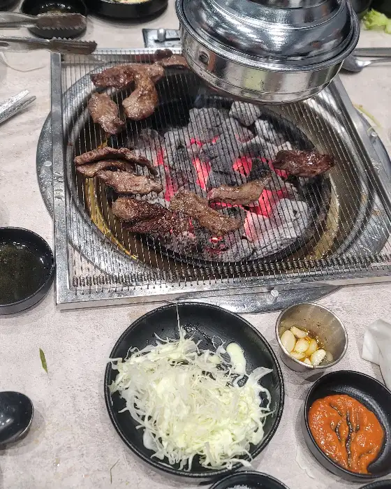 테이블 위에 놓인 신선한 고기와 샐러드바 음식들