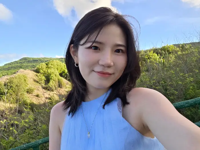 깔끔한 옷차림의 젊은 여성이 미소 짓는 모습