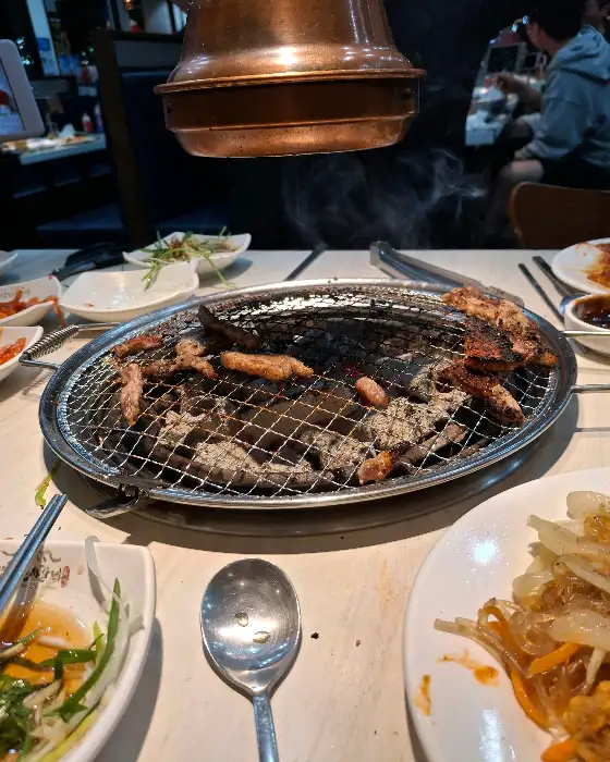 숯불 위에서 구워지고 있는 다양한 고기 조각들