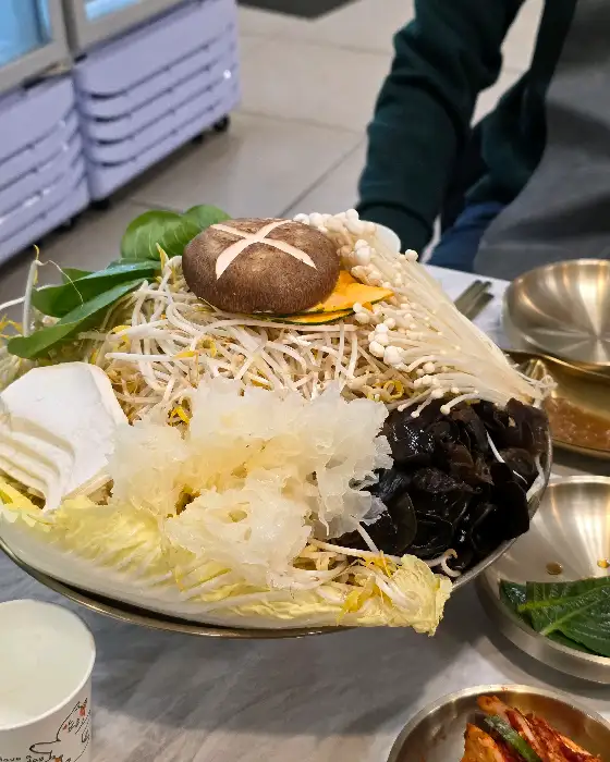샤브샤브 냄비에 담긴 신선한 채소와 버섯