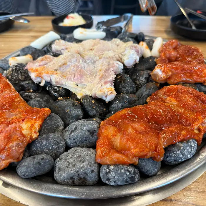 다양한 양념의 닭갈비가 맥반석 위에서 익어가는 모습
