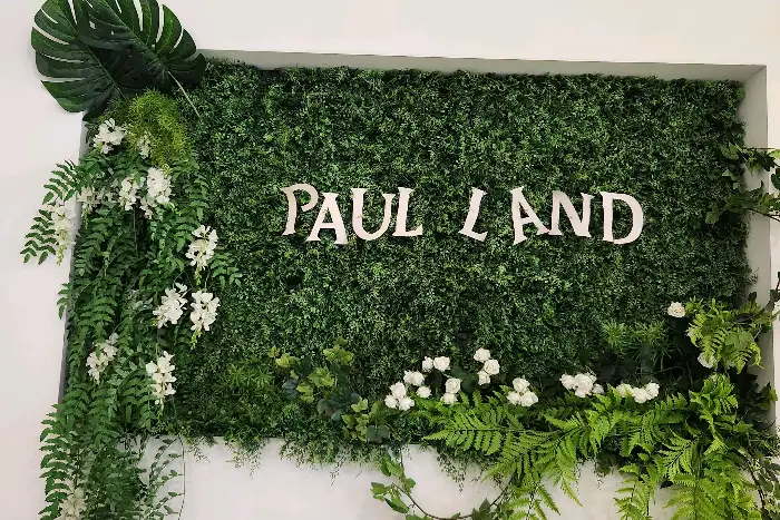 자연 소재로 장식된 'PAUL LAND' 로고 벽면