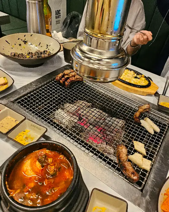 테이블에 놓인 순두부찌개와 곁들임 찬들