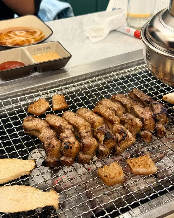 불판 위에서 익어가는 쪽갈비와 곁들임으로 나온 떡