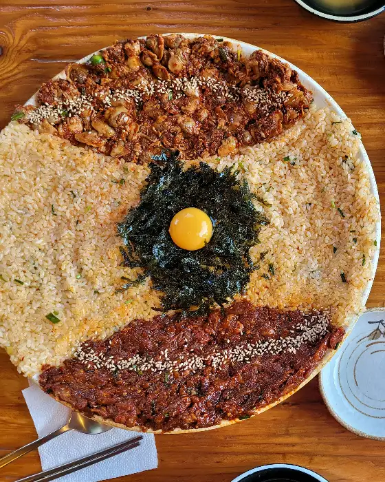 잘 비벼진 밥 위에 토핑들이 얹혀 있는 모습