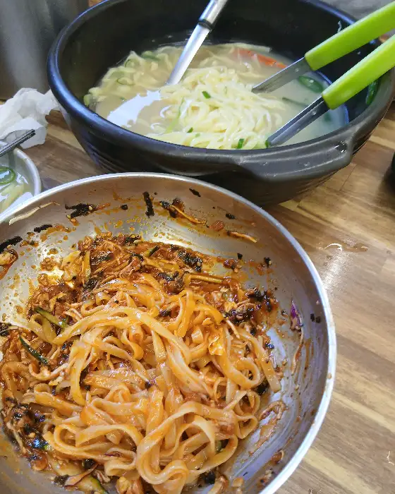 볼에 담긴 비빔칼국수와 그 뒤로 보이는 해물칼국수