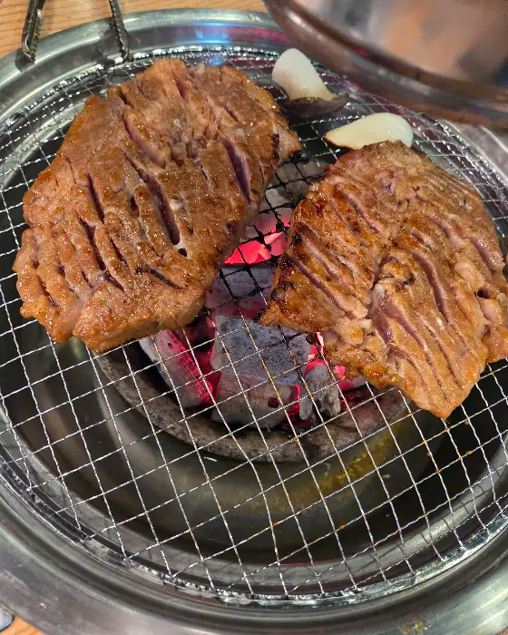 숯불 위에서 익어가는 생갈비 조각