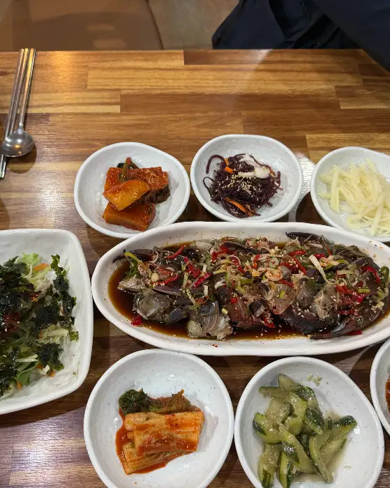 다양한 종류의 밑반찬과 함께 제공된 생선조림 요리 모습