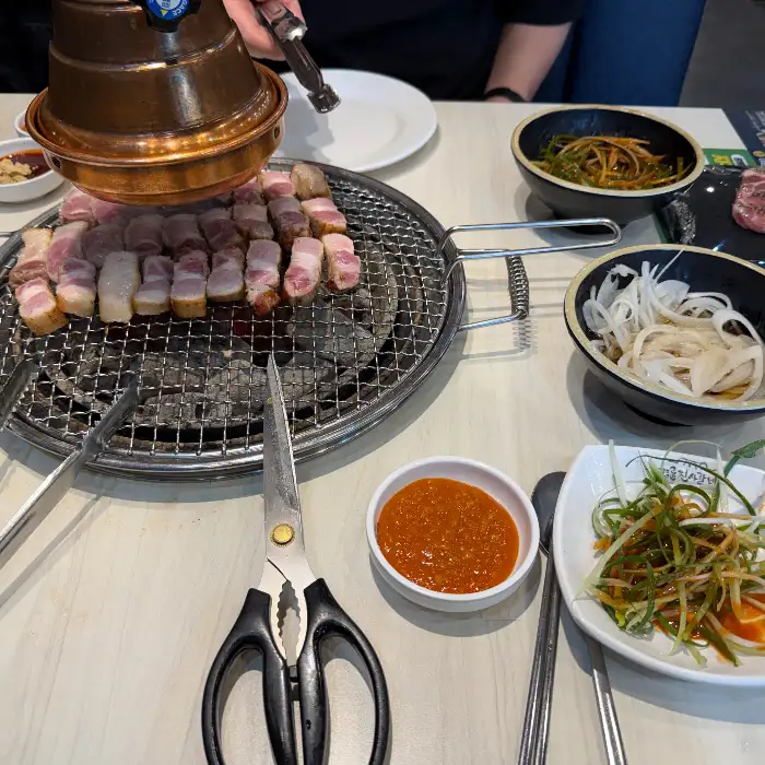 다양한 곁들임 찬과 가위, 집게 등 식사 준비된 모습