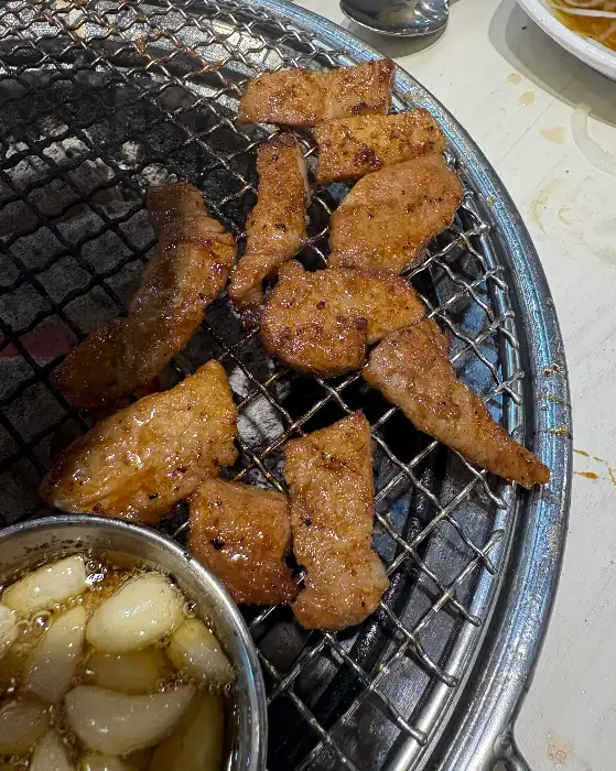 숯불 위에서 바삭하게 구워진 돼지갈비 조각들