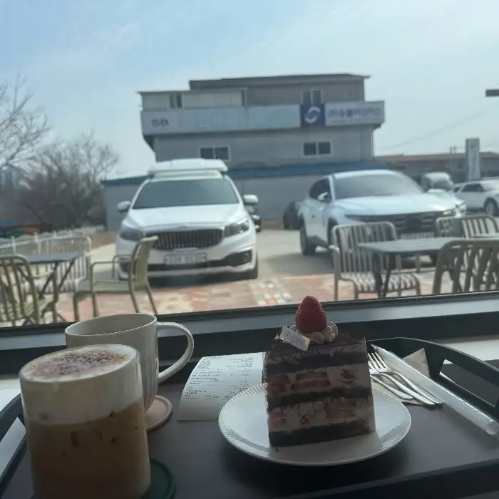 창가 자리와 함께 놓인 커피와 케이크