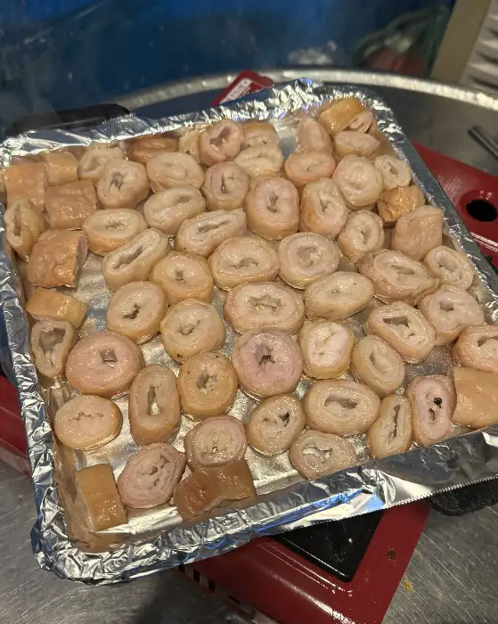 알루미늄 호일 팬에 가지런히 담긴 막창과 마늘, 양파