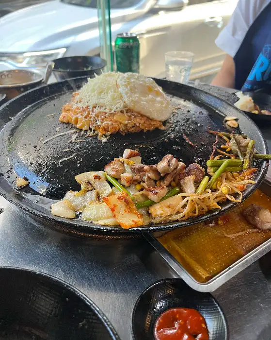 깍두기 볶음밥 위에 계란 프라이와 치즈가 듬뿍 올라간 모습