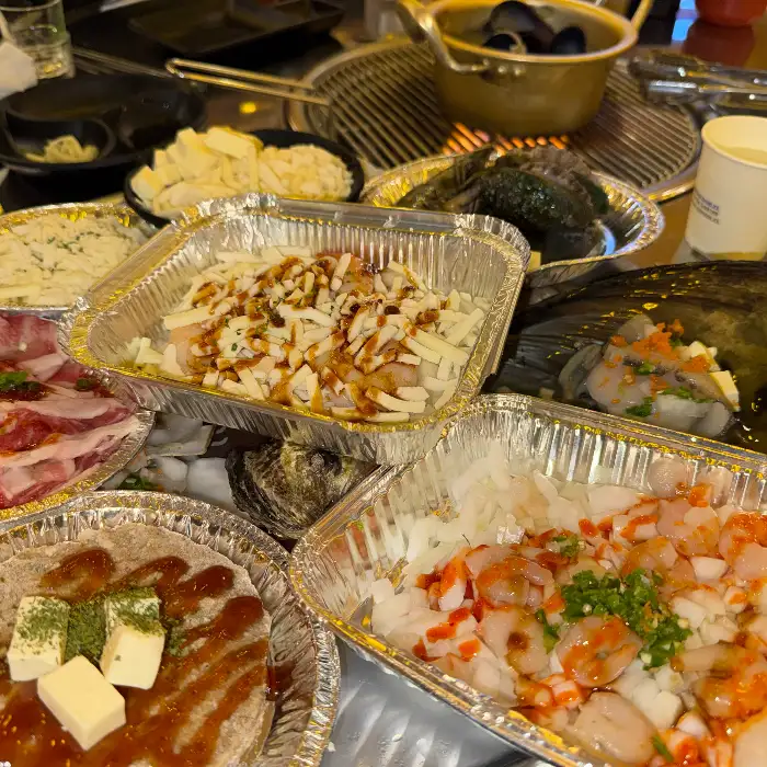 치즈와 함께 구워지고 있는 조개와 새우