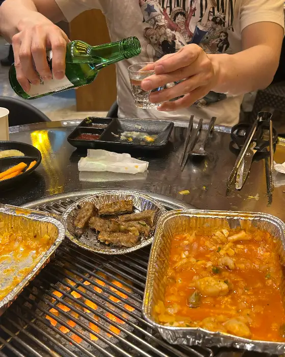 직원이 소주잔에 술을 따르고 있는 모습