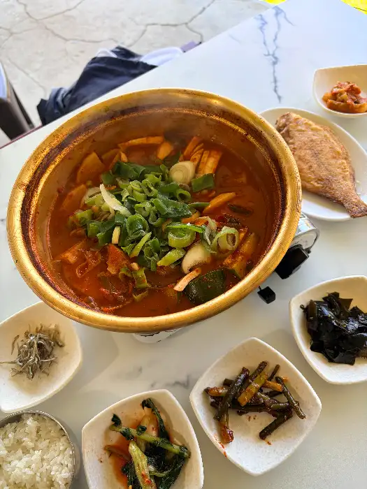 따뜻한 멸치쌈밥이 담긴 냄비와 밑반찬